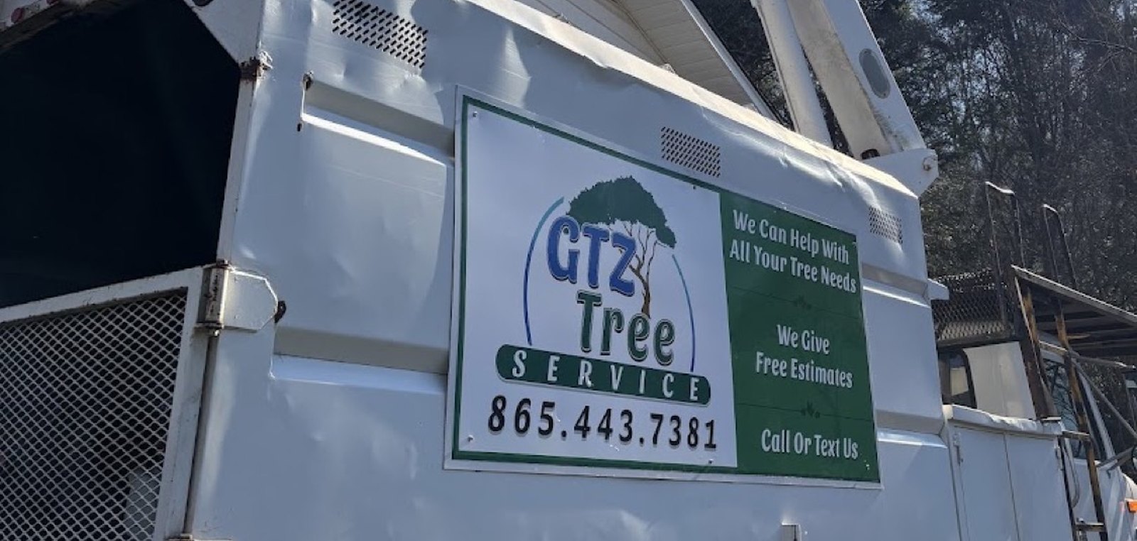 The branded GTZ Tree Service bucket truck, its signboard offering free estimates