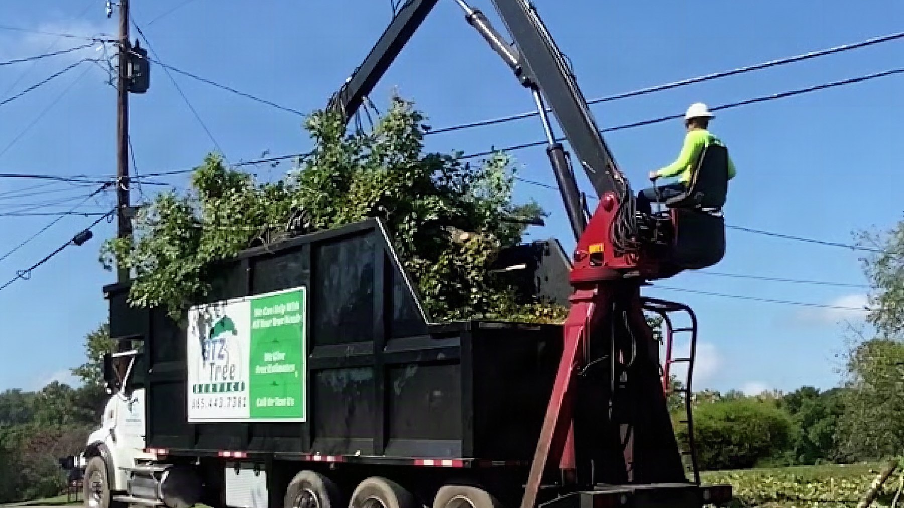The GTZ Tree Service crew loading brush into the chip truck on a Knoxville street