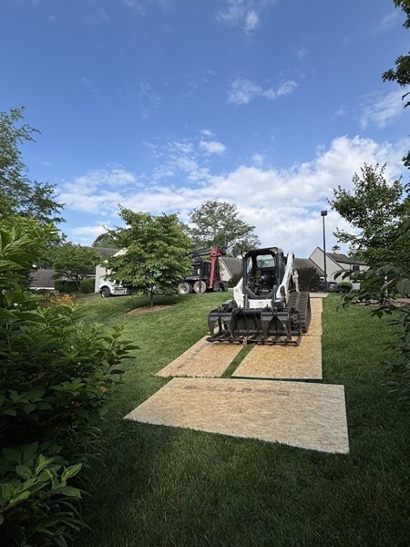 A GTZ skid steer on ground protection mats across a Knoxville lawn