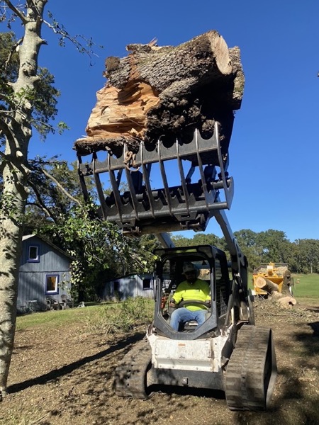 Log loader lifting heavy timber off a cleared site